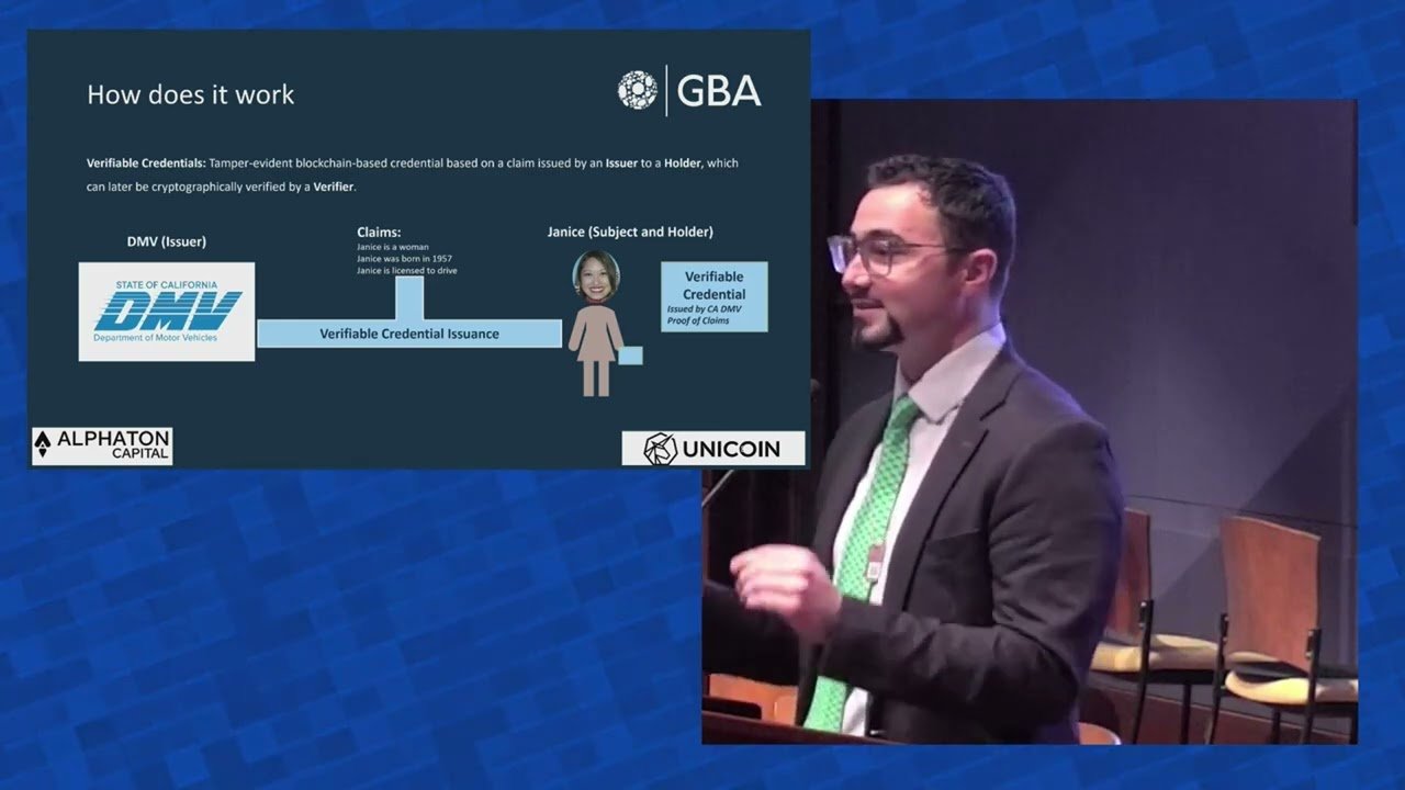Dominic speaking at the GBA Blockchain Showcase beside a slide explaining how verifiable credentials are issued by the California DMV to a holder